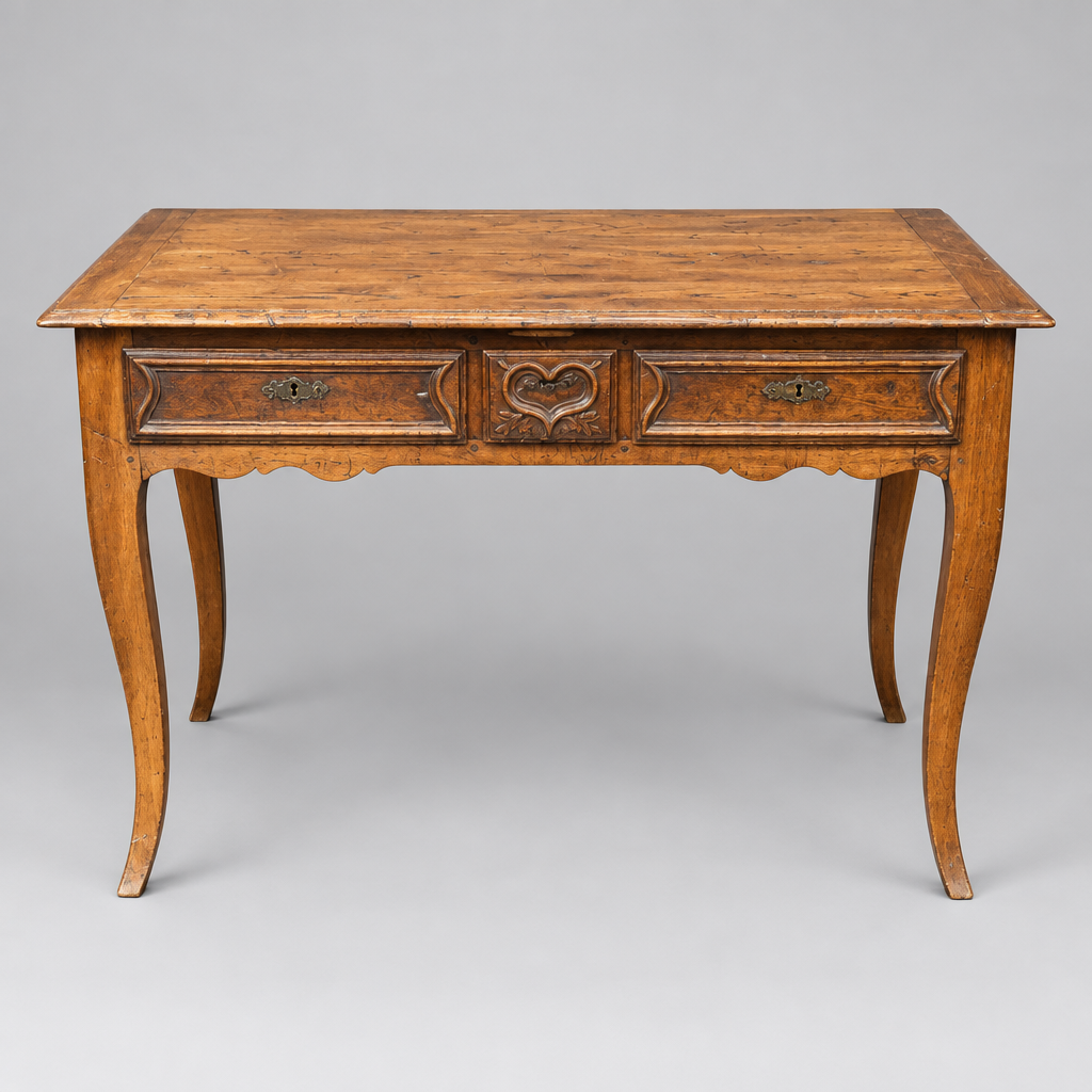 An antique wooden writing desk with two drawers, featuring a rich grain pattern and curved cabriole-style legs, photographed against a neutral gray background.