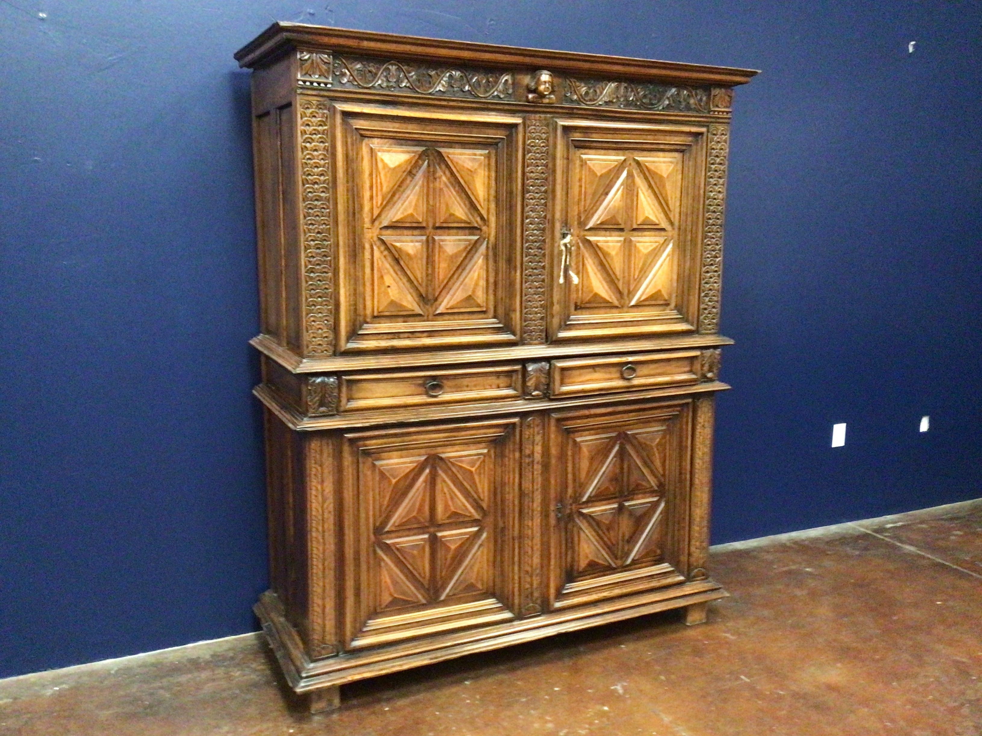 Wooden cabinet with intricate designs against a blue wall