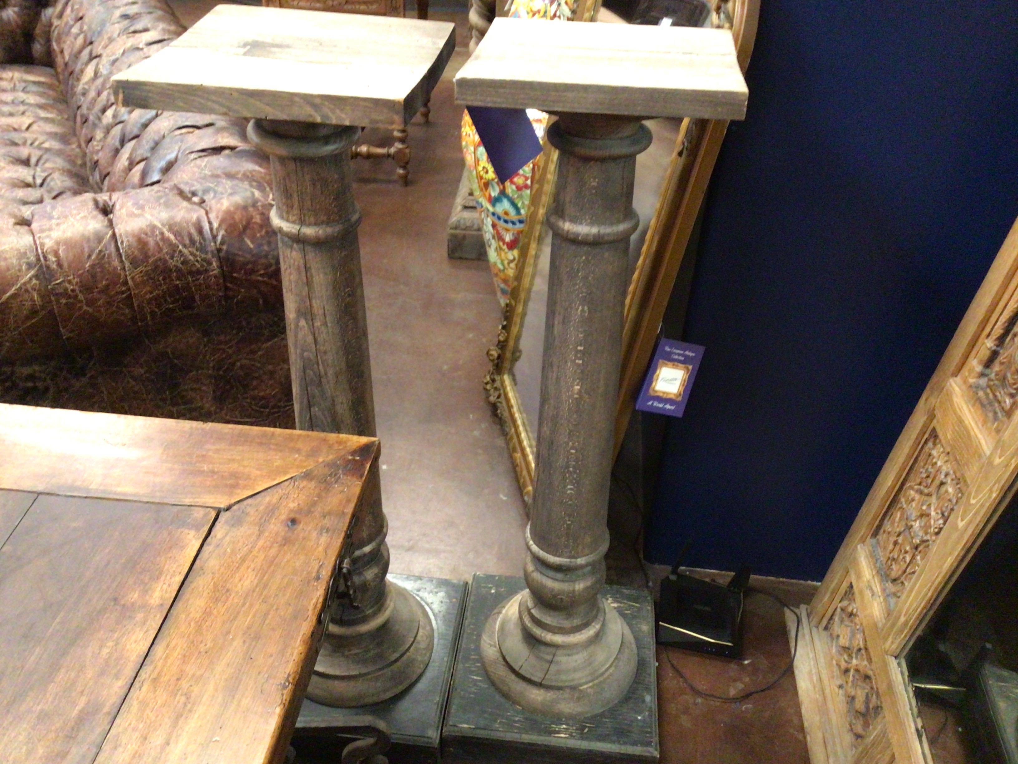Decorative columns with a mirror and furniture in the background