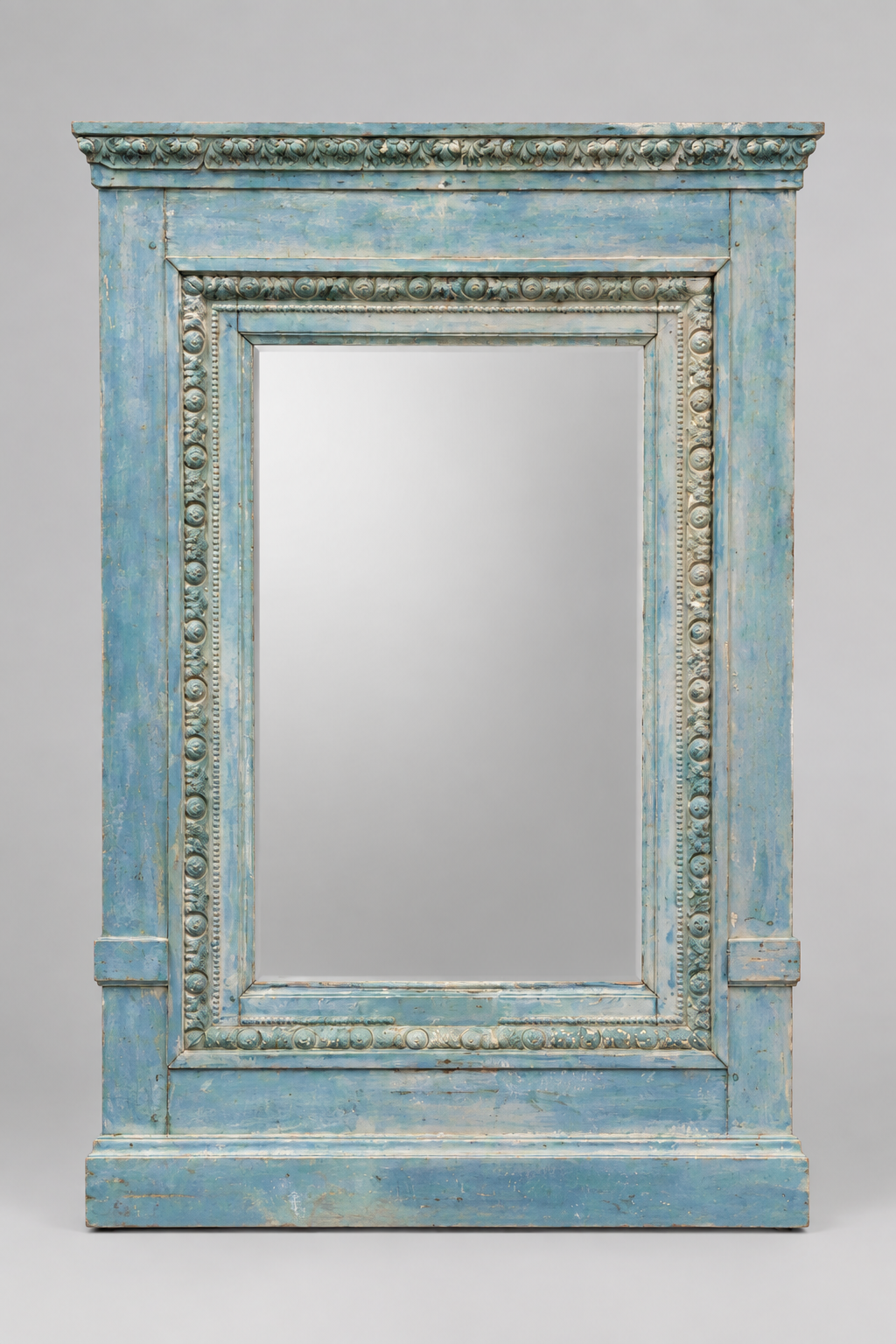 A large rectangular wall mirror with an ornate distressed blue wooden frame, set against a neutral gray background.