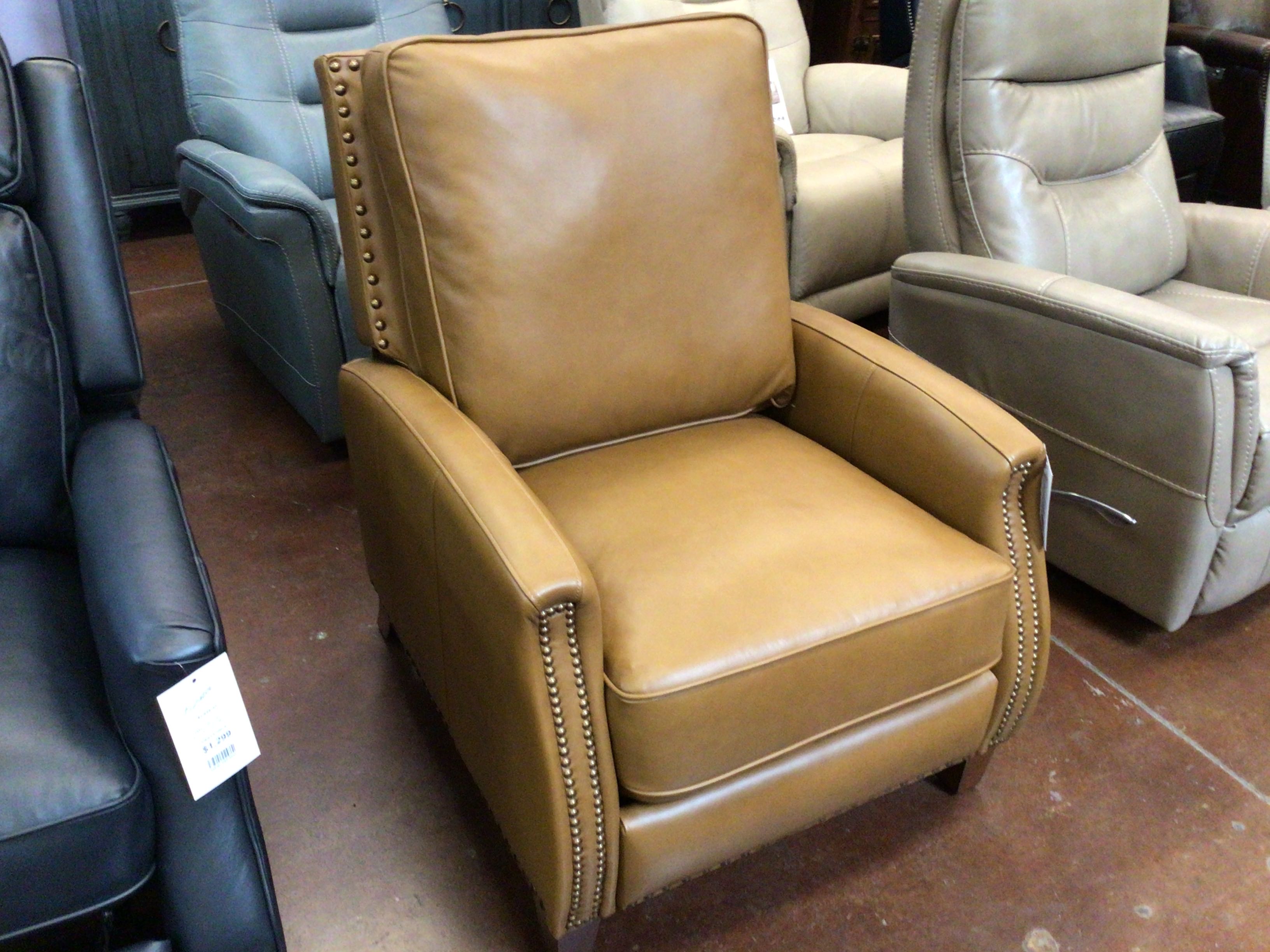 Brown leather recliner chair in a showroom setting with other chairs.