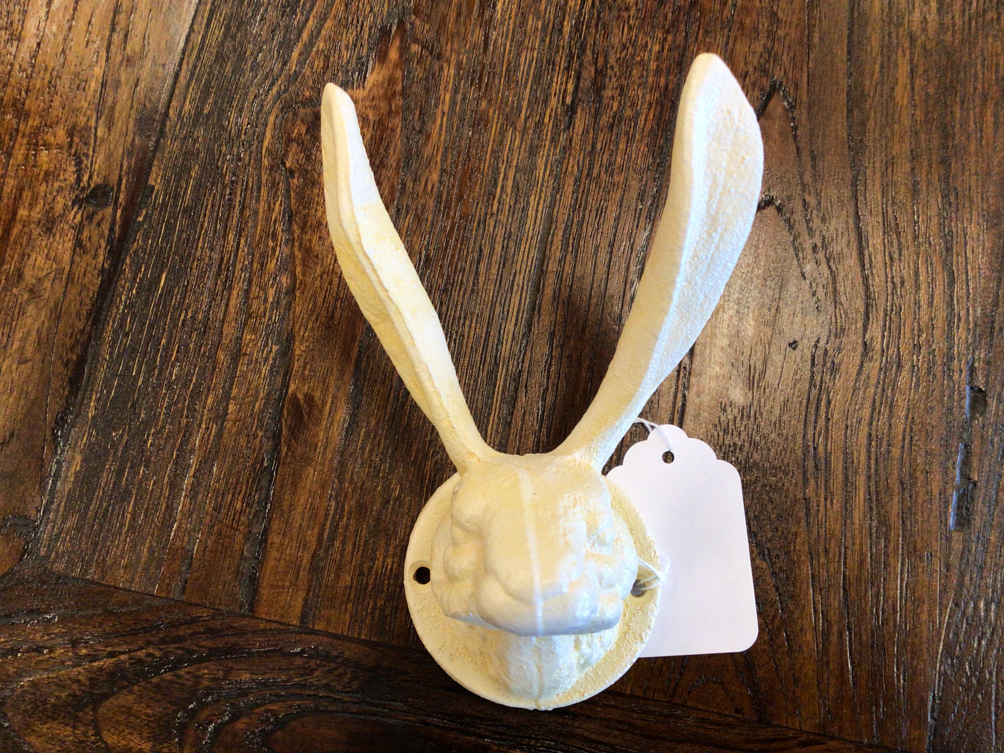 Decorative rabbit head wall mount with a tag on a wooden background