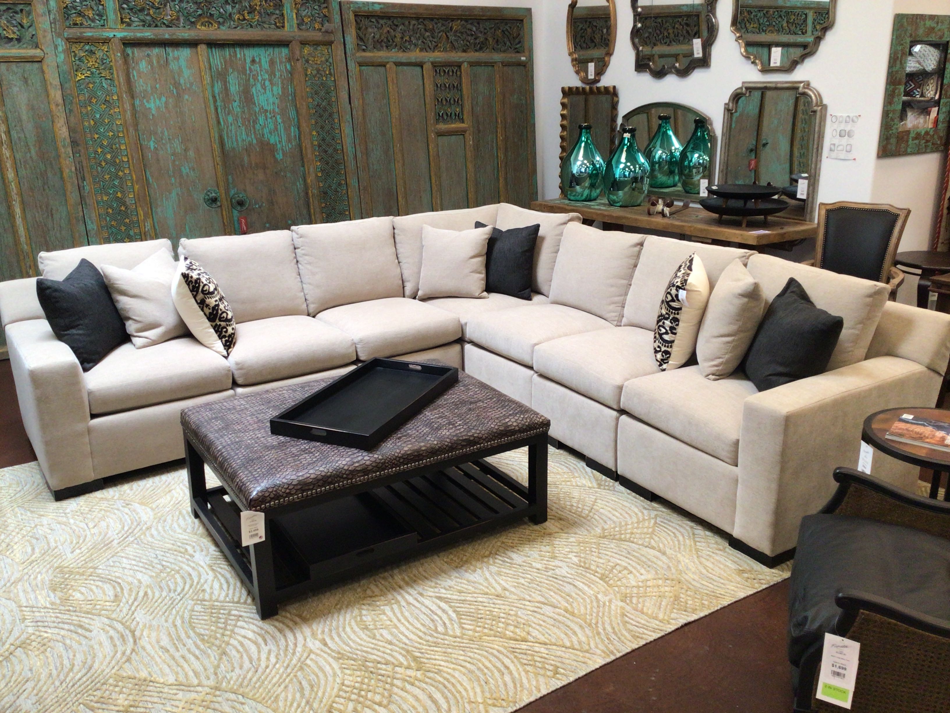 Beige sectional sofa with dark coffee table on a gray background