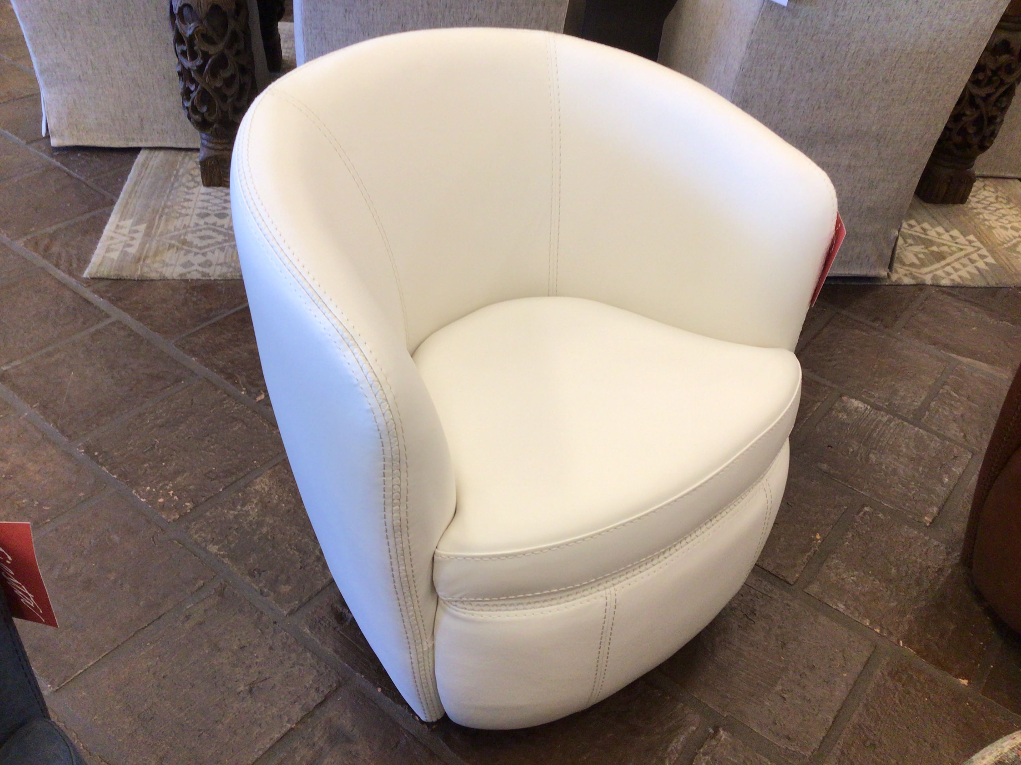 White armchair on a tiled floor with a Coca-Cola sign in the background