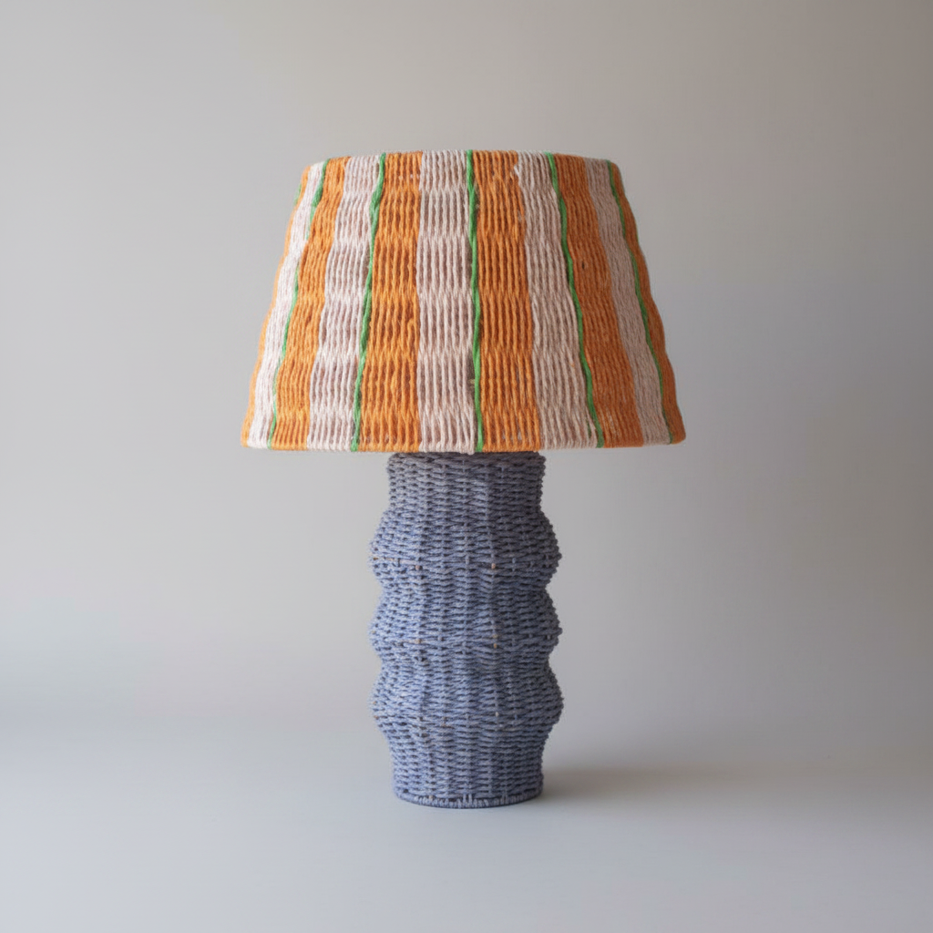 Decorative lamp with striped shade on a wooden table