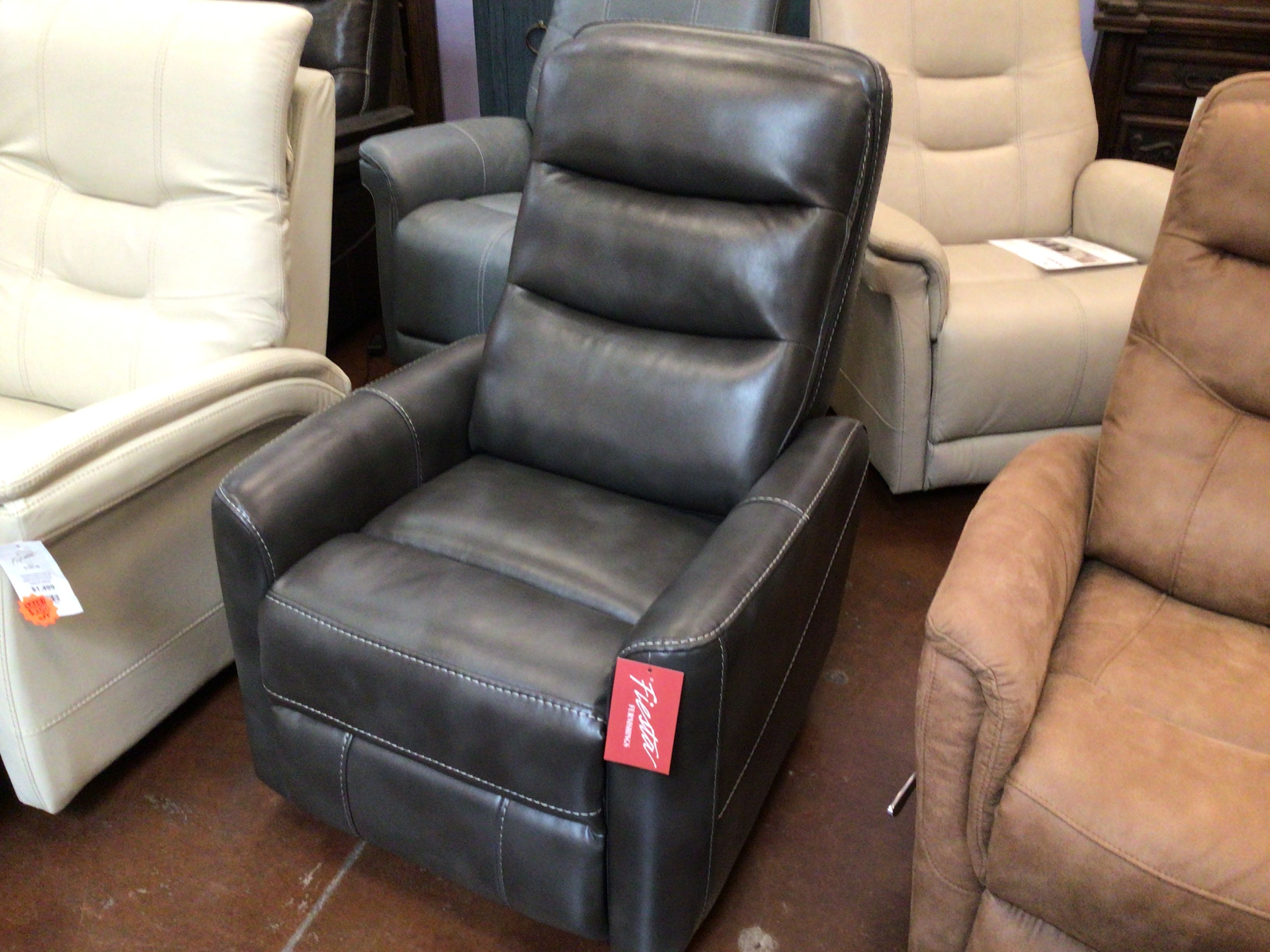 Slate leather recliner chair in a furniture store with other chairs in the background.
