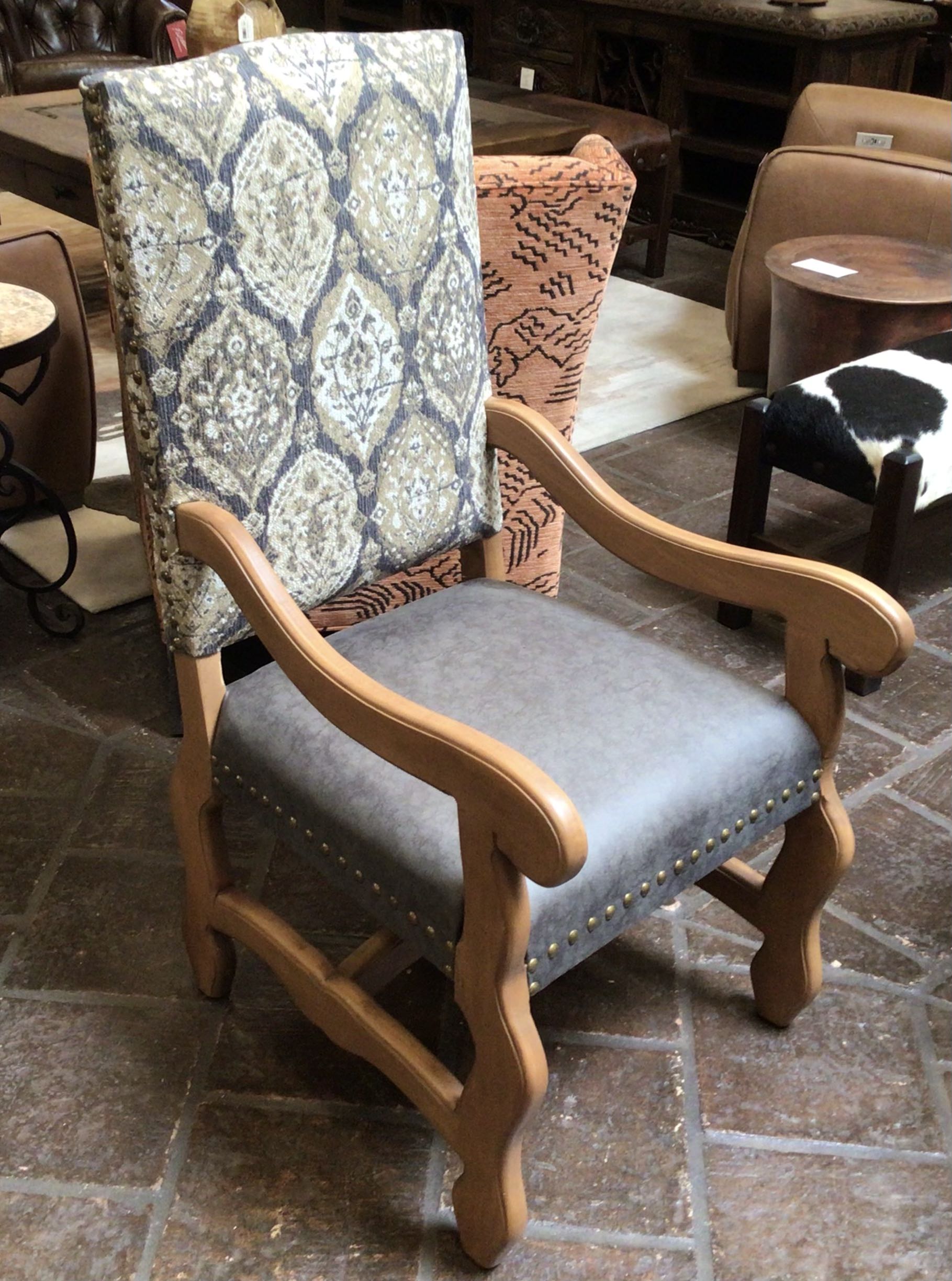 Chair with patterned backrest and gray cushion on a stone floor.