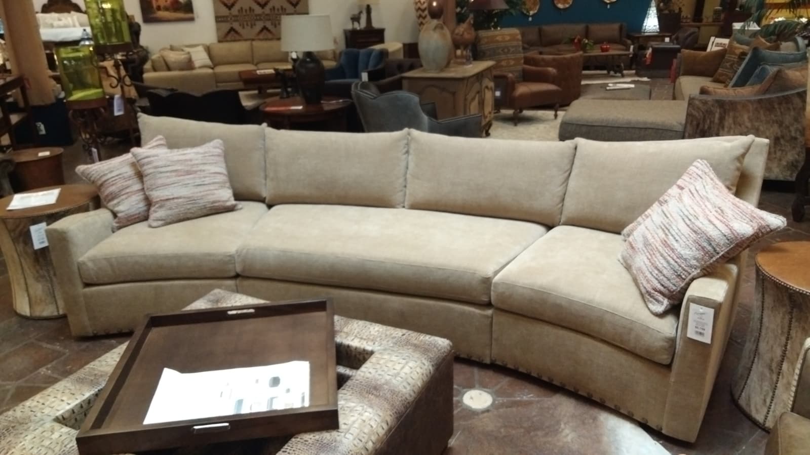 Beige sectional sofa in a furniture store with various items around