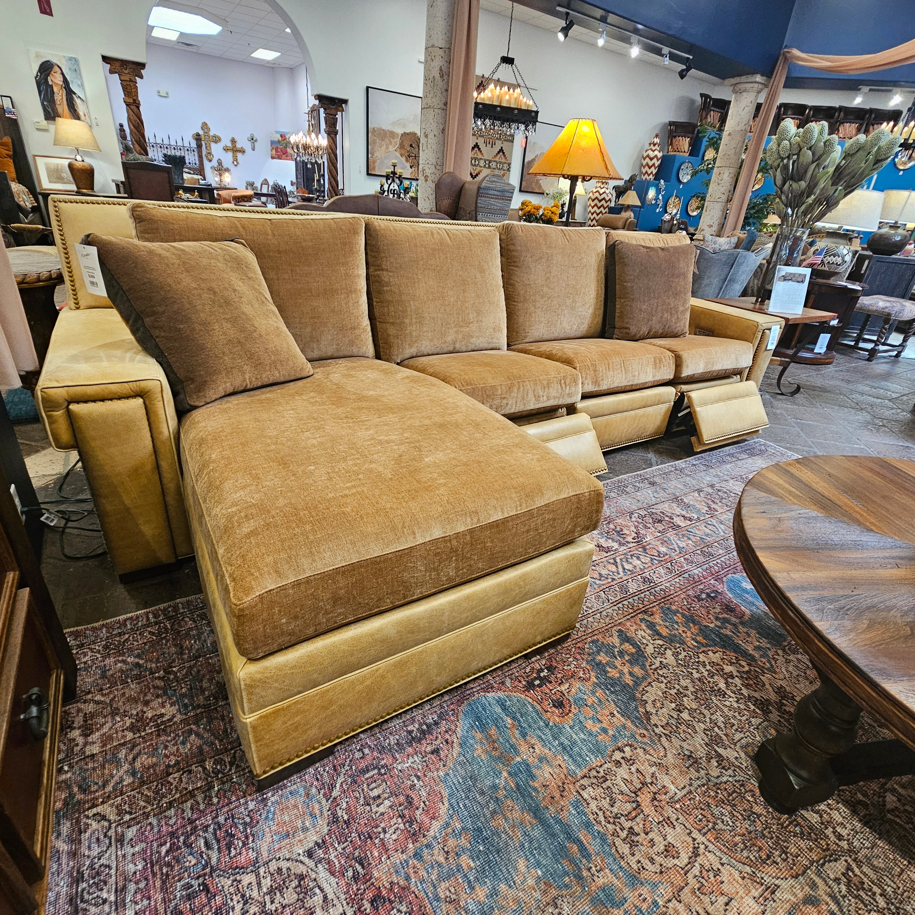 Brown sectional sofa in a showroom with various decor items.