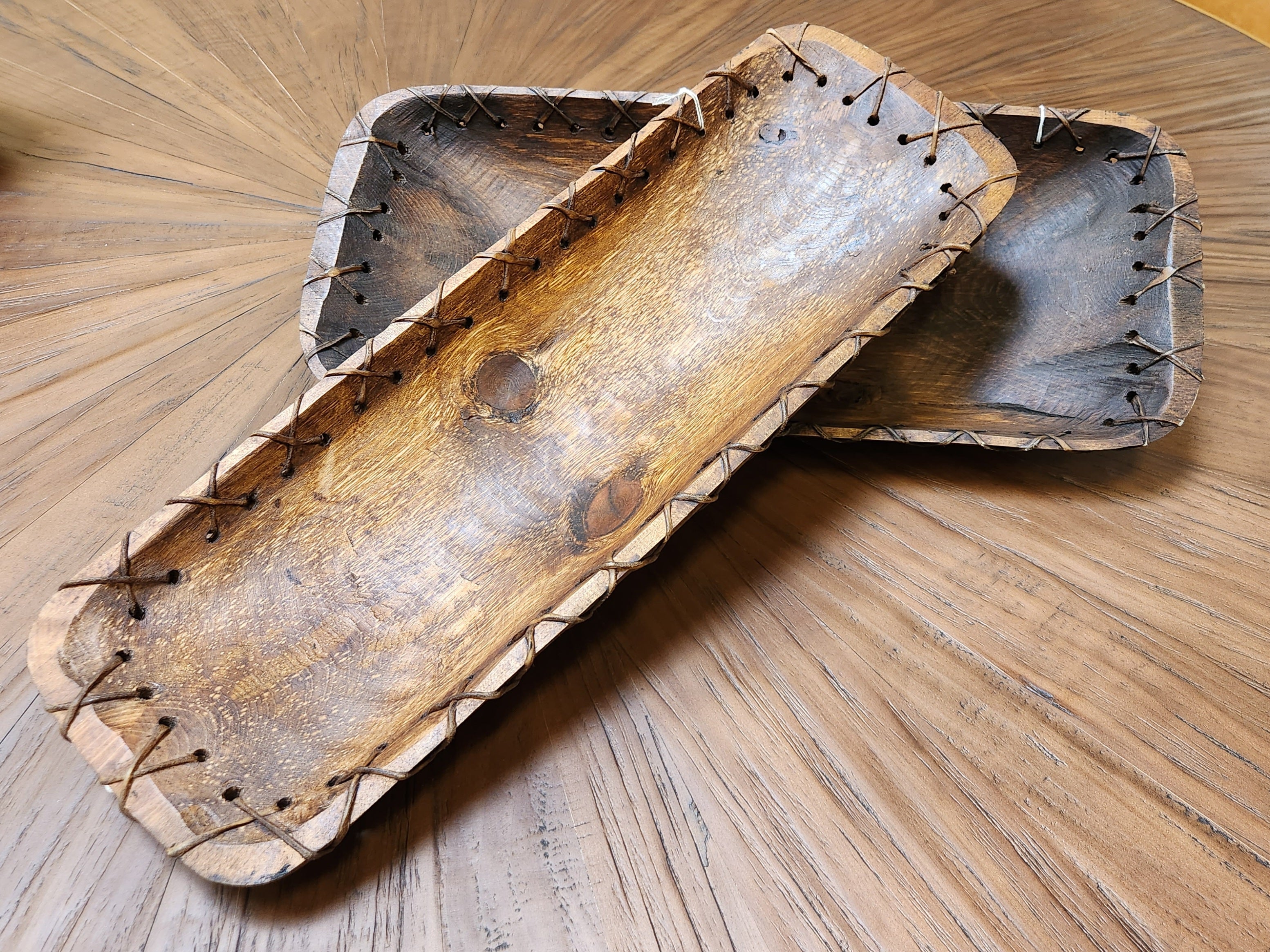 Wooden tray with metal nails on a wooden surface