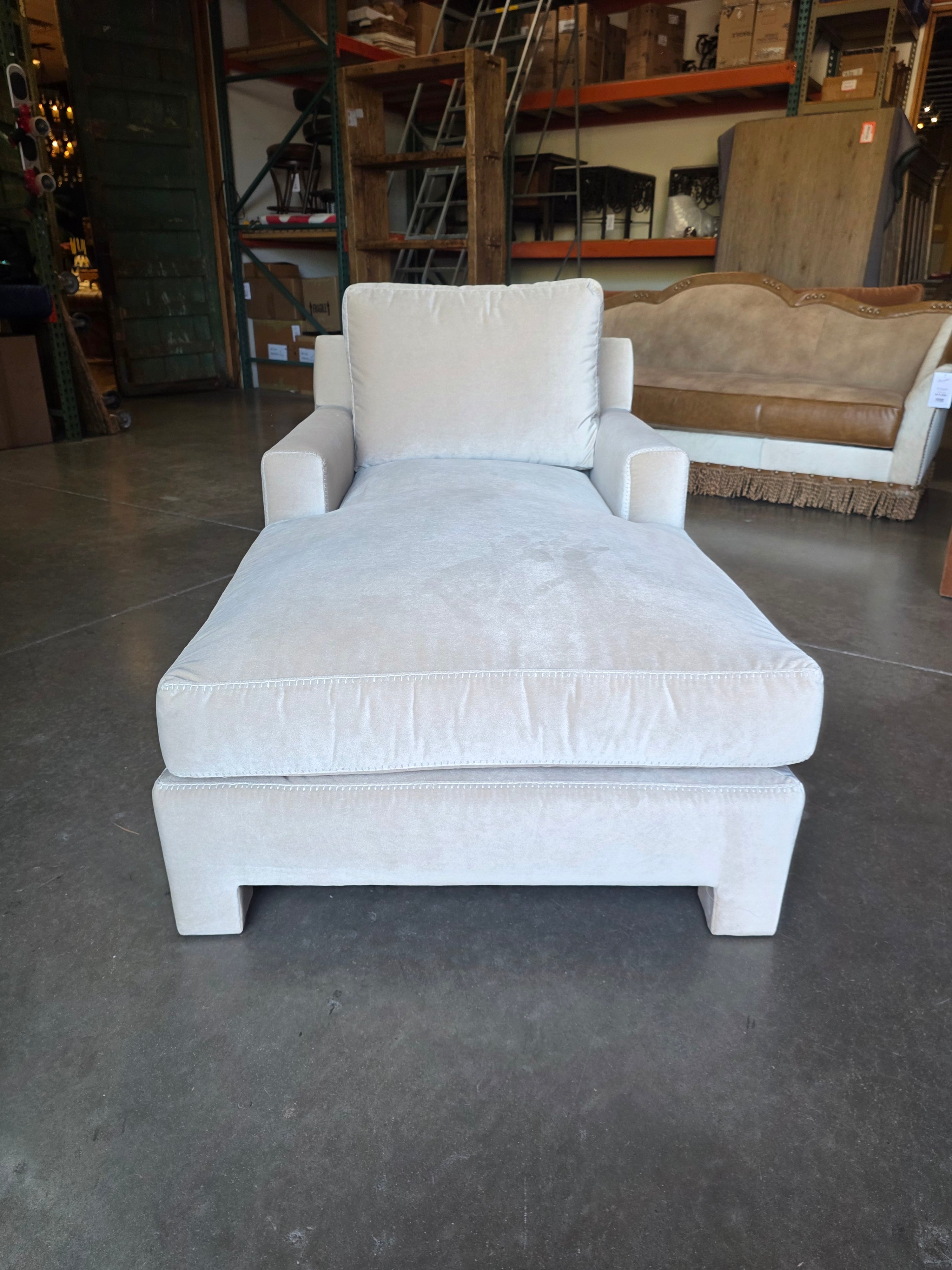 White armchair on a dark gray floor with a blurred background