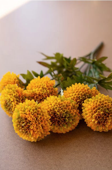 Bouquet of yellow marigold flowers on a beige surface