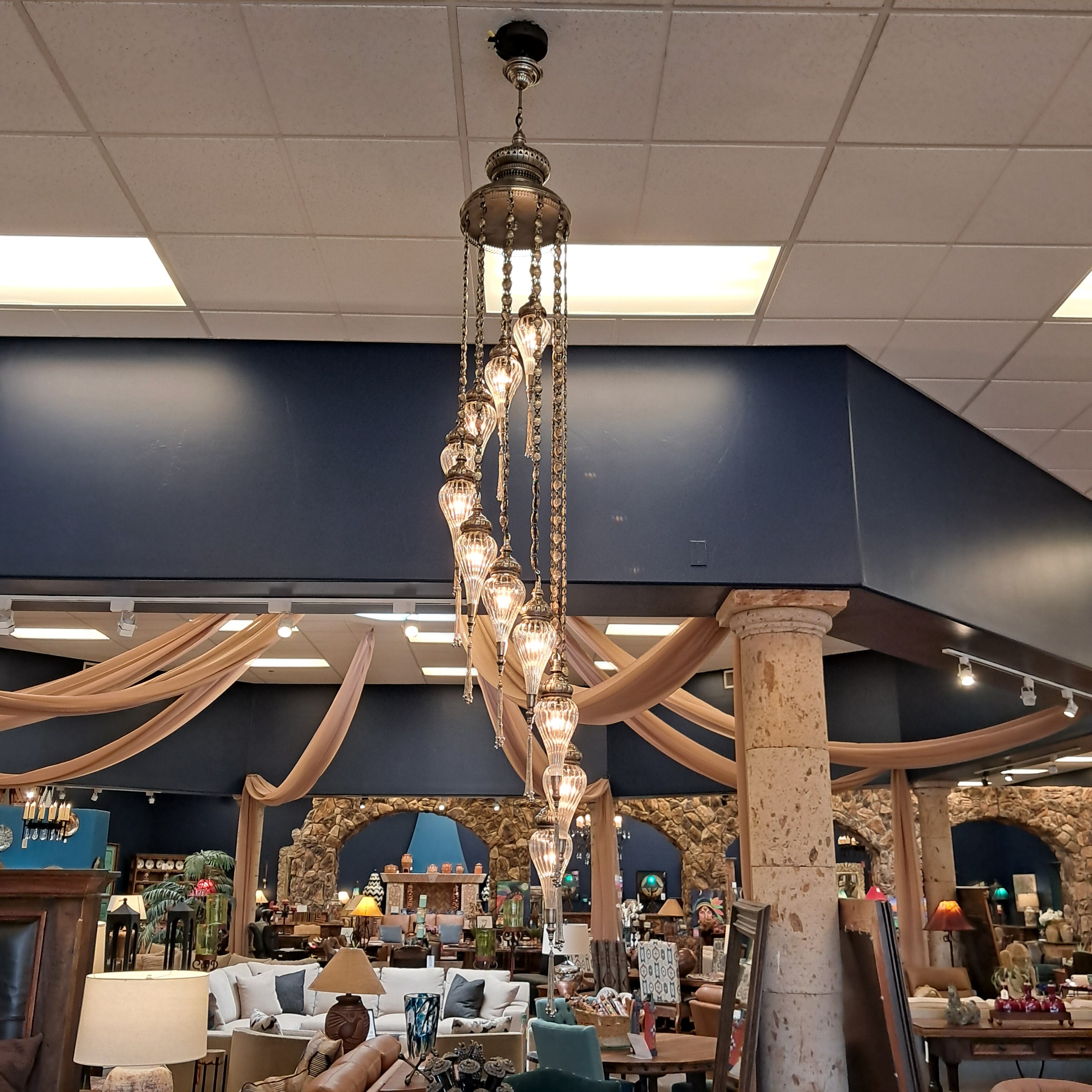 Chandelier hanging in a room with a bar and mirror