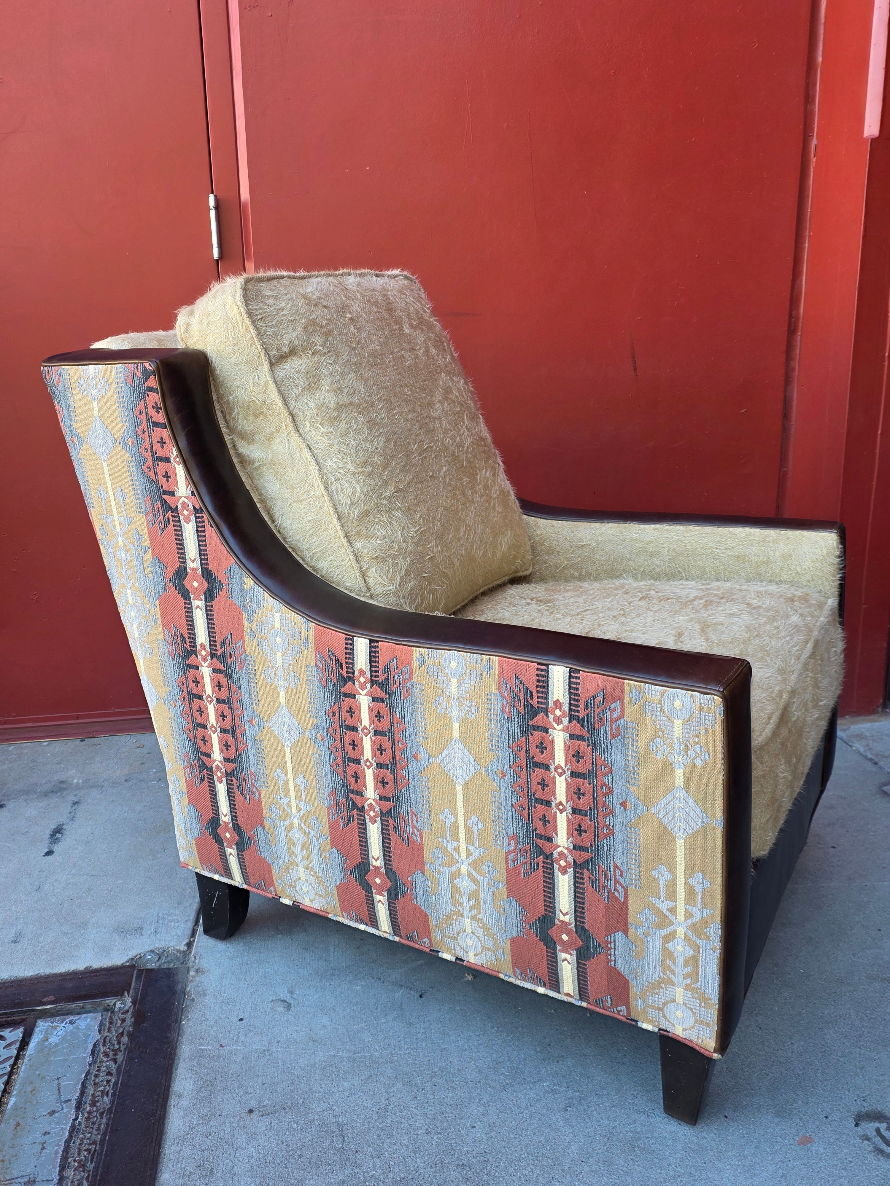 Accent chair with patterned top and cushioned seat against a red wall.