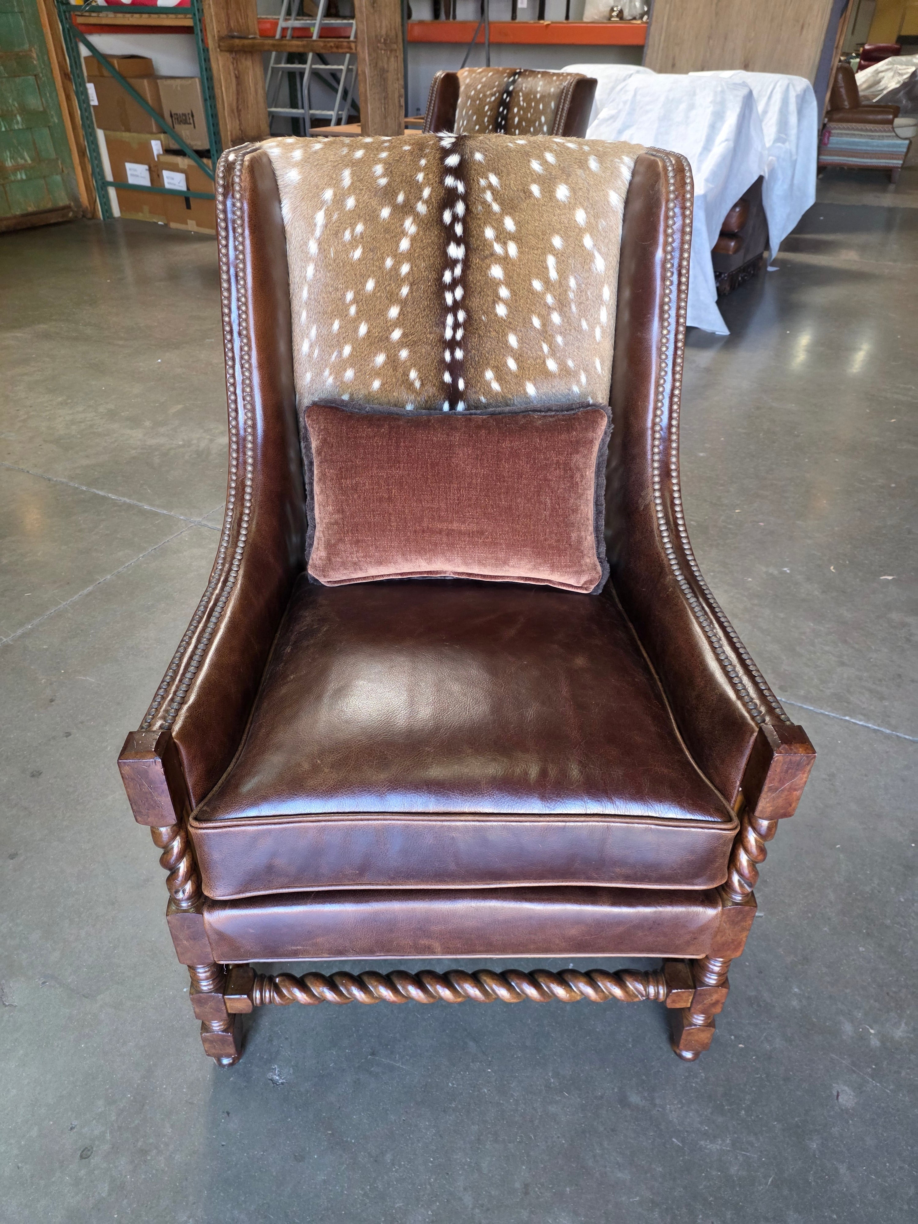 Brown leather armchair with decorative elements against a gray wall.