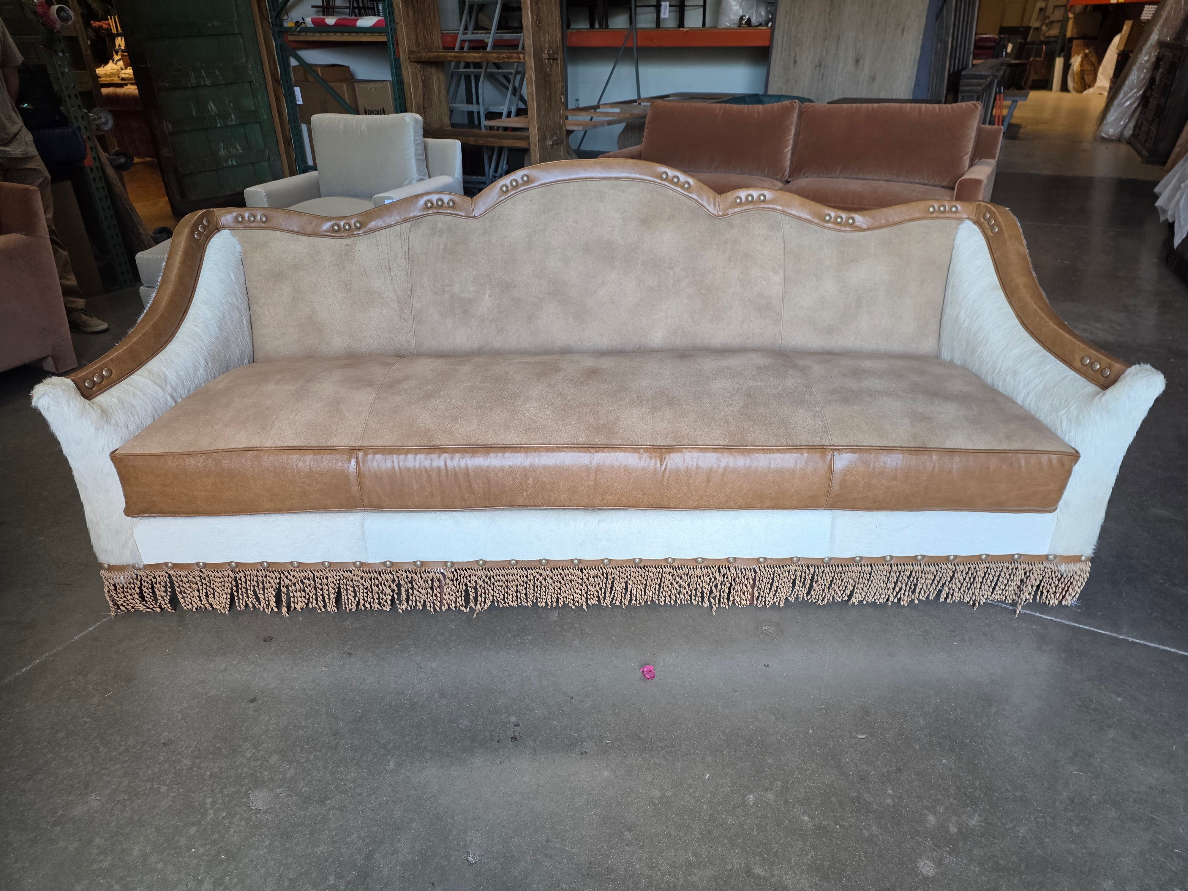Decorative sofa with beige and brown upholstery in a storage or warehouse setting.