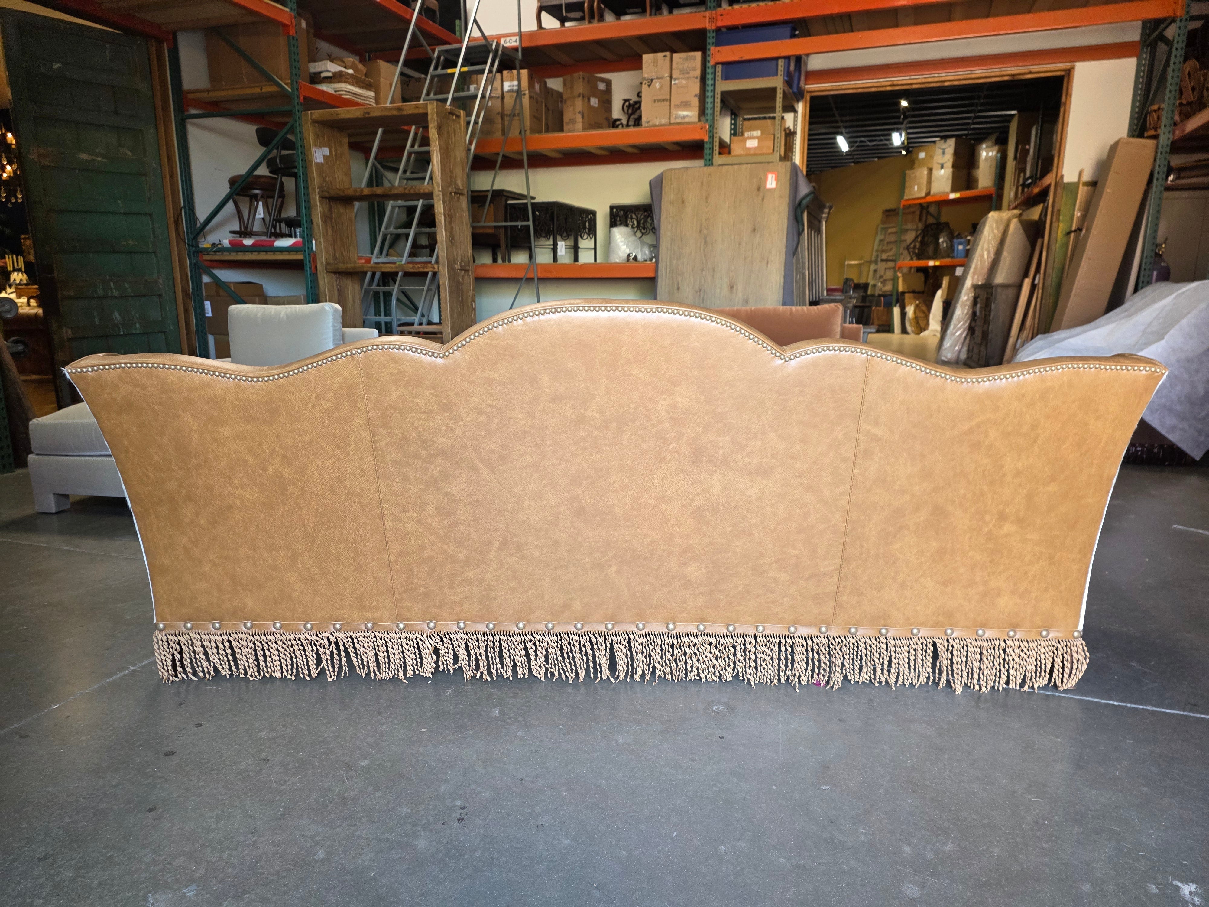 Beige upholstered headboard with fringe details in a warehouse setting