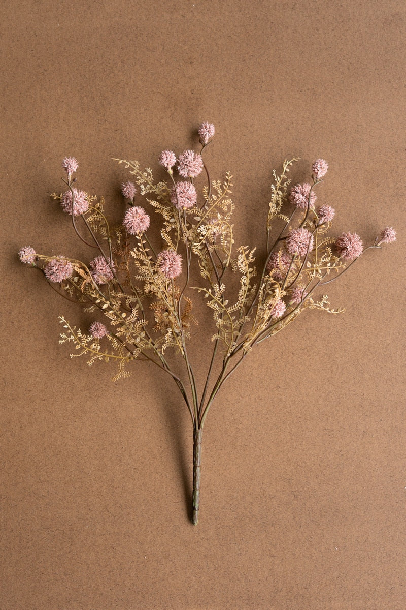Dried floral arrangement with pink flowers on a brown background