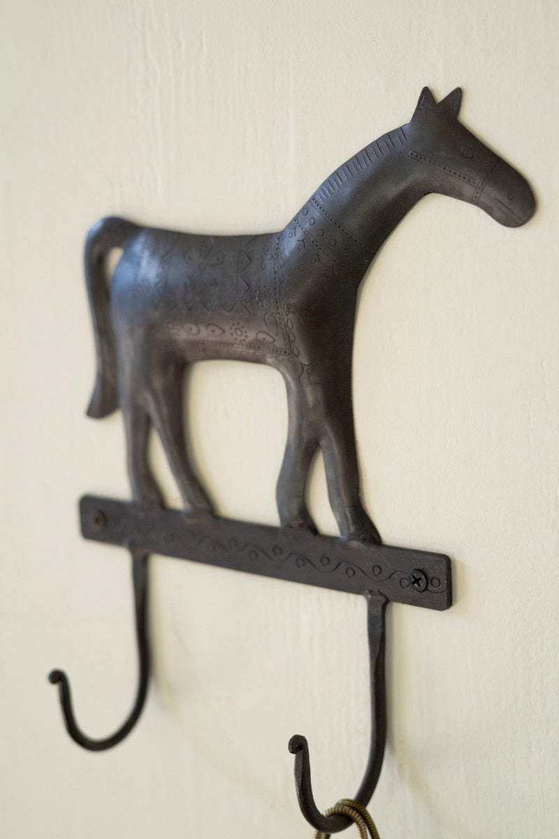 Decorative metal wall hook shaped like a horse on a white background