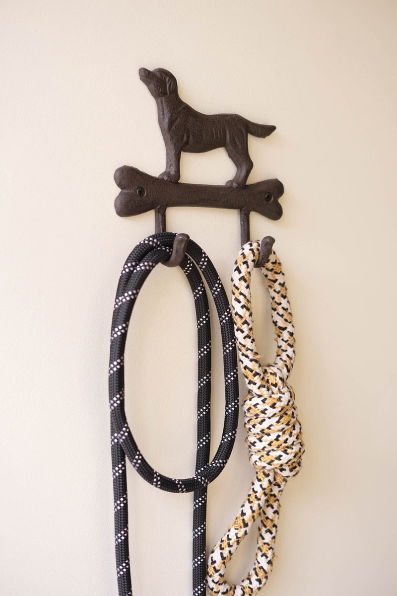 Dog leash holder with two leashes attached on a white wall
