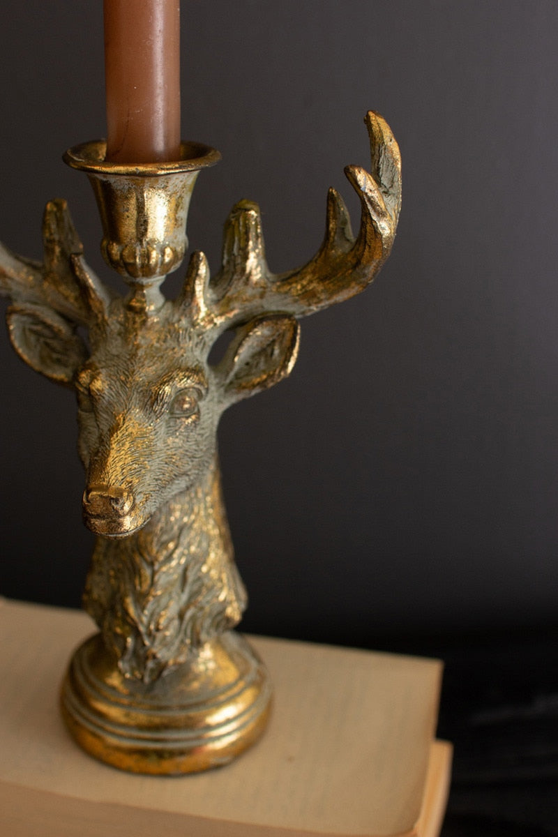 Gold deer head candle holder on a dark background