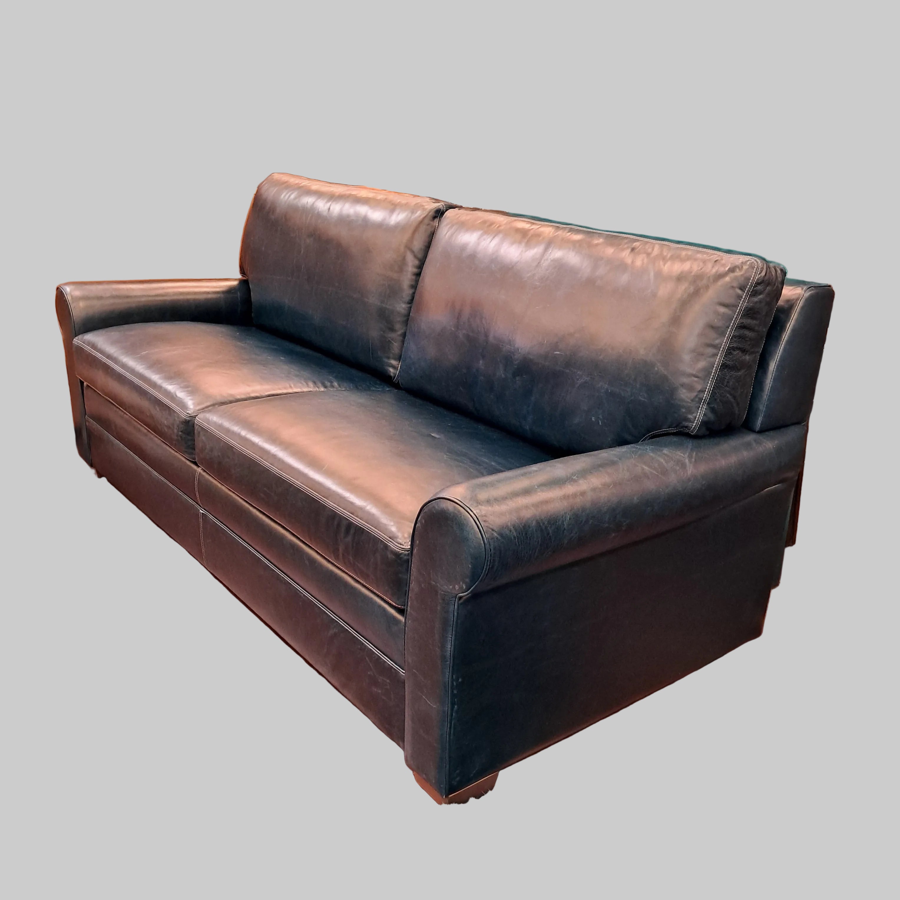 Dark leather sofa in a room with a green wall and decorative elements.