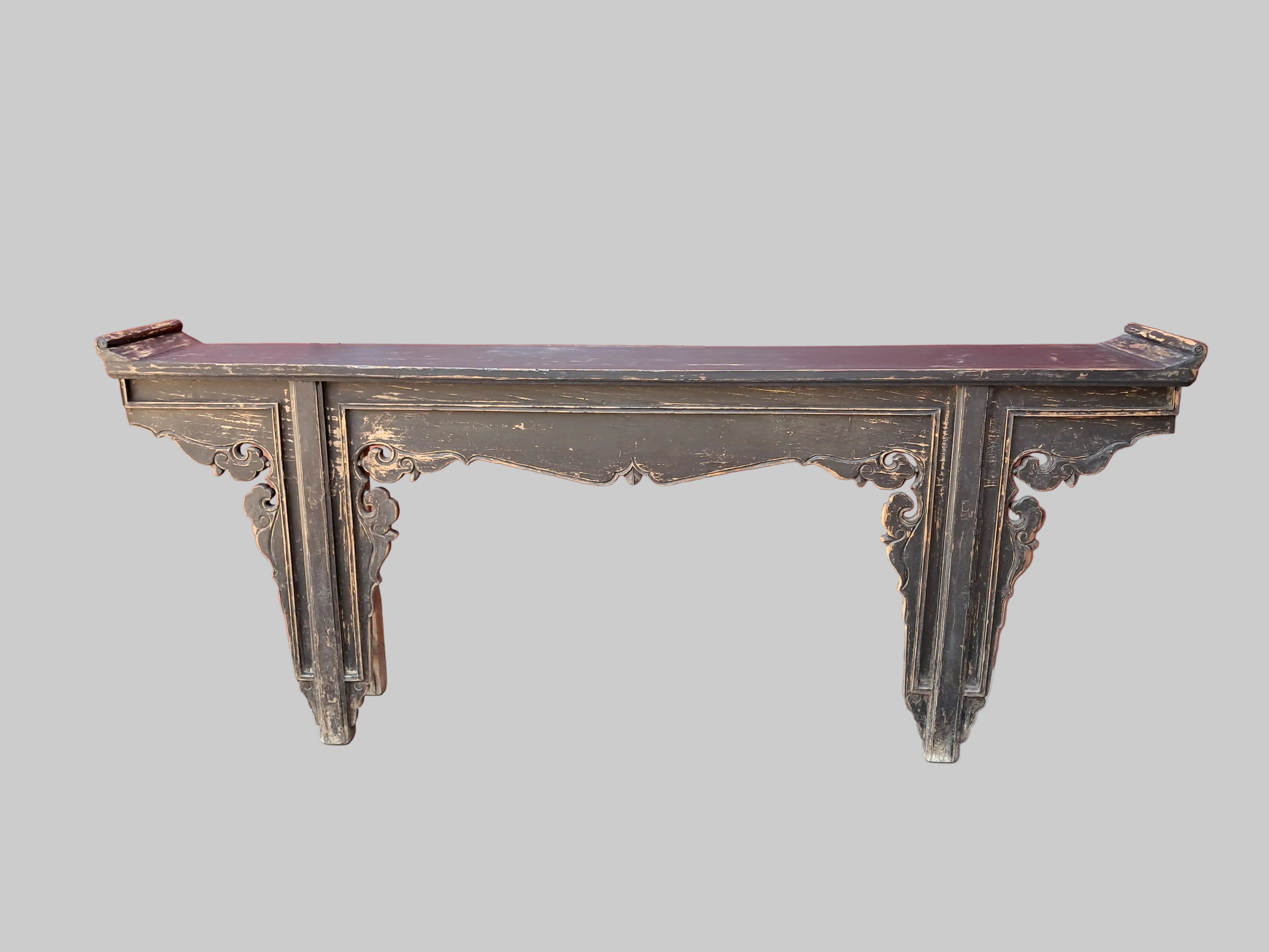 Vintage wooden console table against a red wall