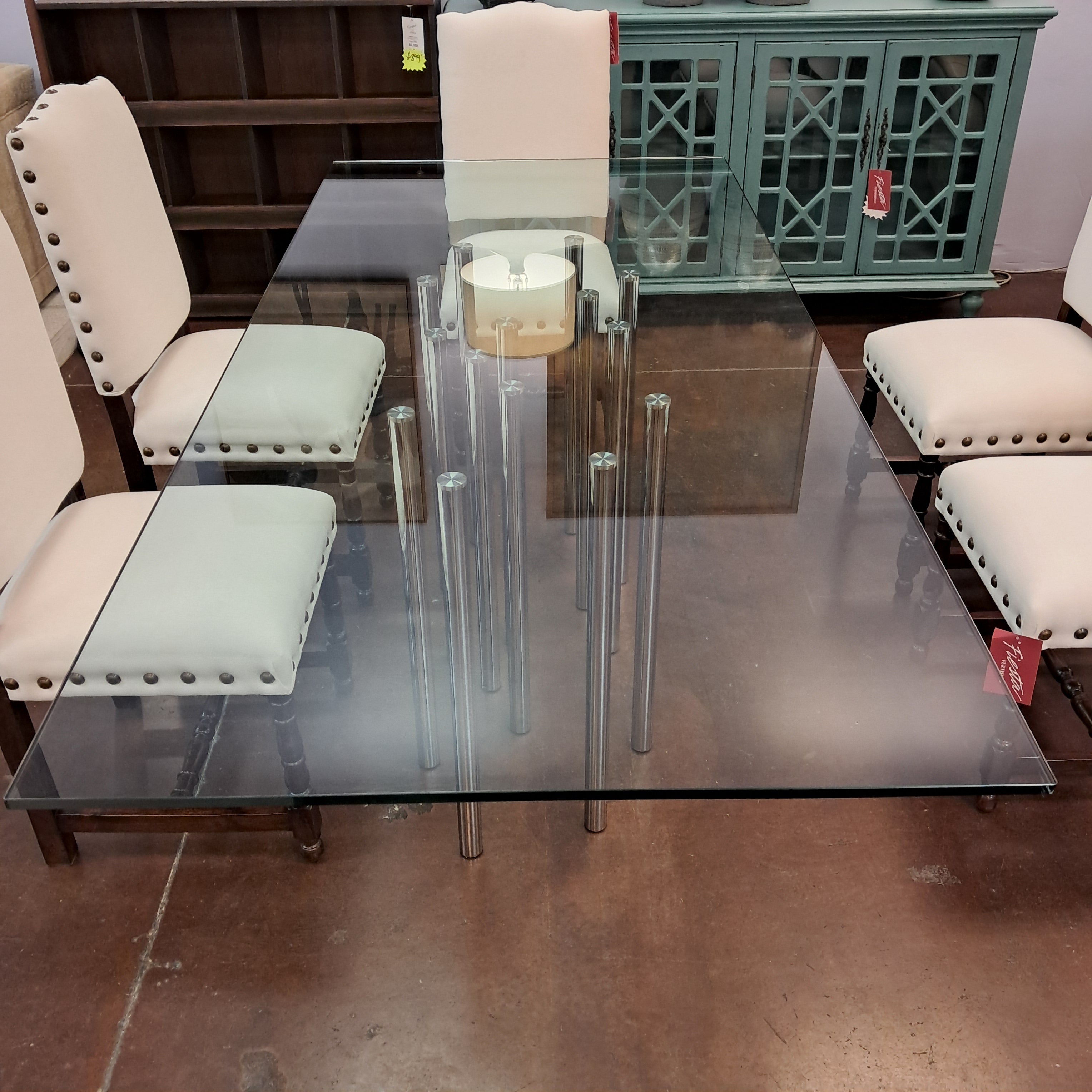Glass dining table with metal legs in a room setting