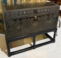 Leather trunk with brass nailhead ornament raised on a black wrought iron stand