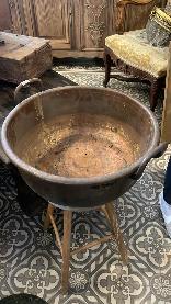 Large copper jam pan on a turned wooden stand with deep rose patina and honest denting
