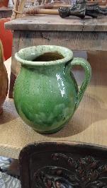 Green glazed terracotta water jar with a glossy pooling glaze and a single loop handle