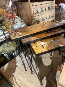 Three graduated nesting tables with Lascaux cave painting tile tops on slender black iron legs