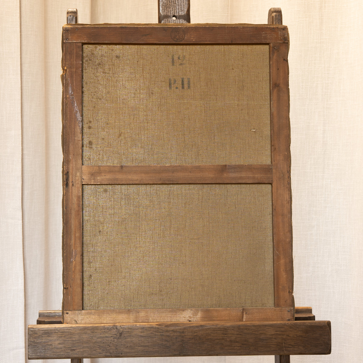 A vintage wooden display stand or easel with two rectangular woven fabric panels attached to the front, photographed against a light beige curtain backdrop.