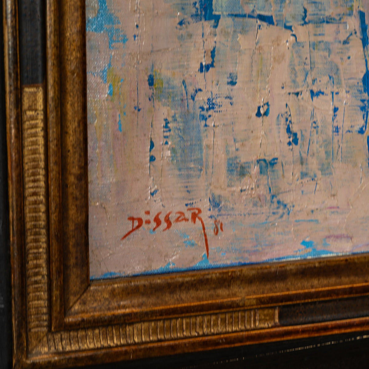 Close-up of a framed painting showing an abstract textured composition in blue, beige, and white tones, with a red signature reading 'Dissar' near the lower left corner and a carved gold-toned frame.