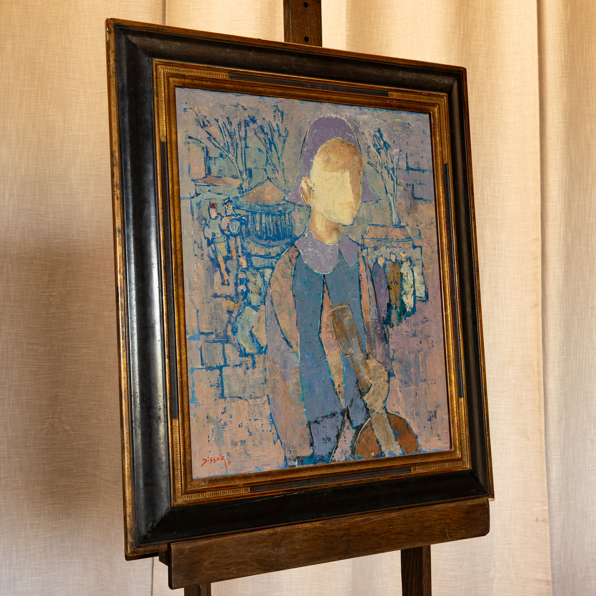 A framed portrait painting of a figure holding a guitar, displayed on a wooden easel against a beige curtain background. The painting features textured blue, purple, and beige brushstrokes, enclosed in a dark brown wooden frame.
