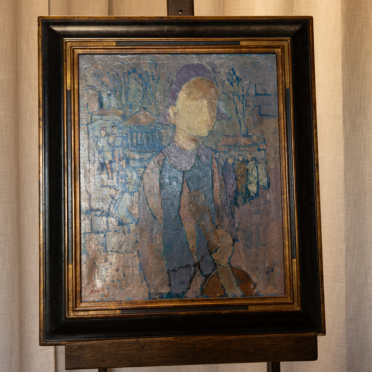 A framed painting on an easel, depicting a stylized figure in blue and purple tones against a textured background, with a dark wood frame and gold inner trim.