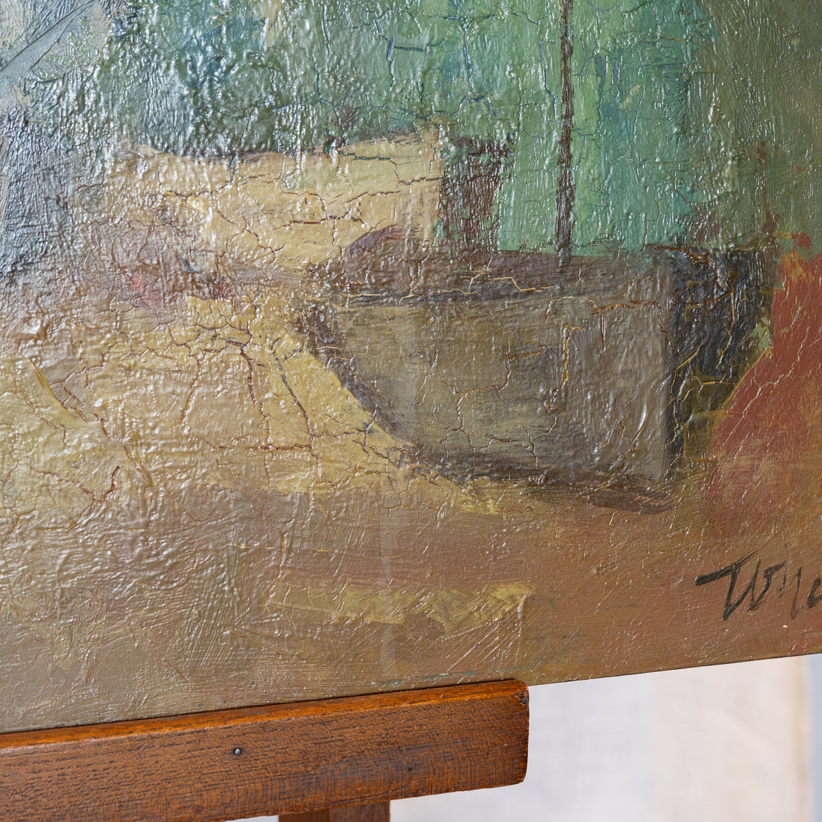 A close-up of an oil painting on canvas depicting a boat scene, mounted on a wooden easel. The painting features thick, textured impasto brushstrokes in earthy tones of brown, beige, green, and red, with a visible artist signature in the bottom right corner.