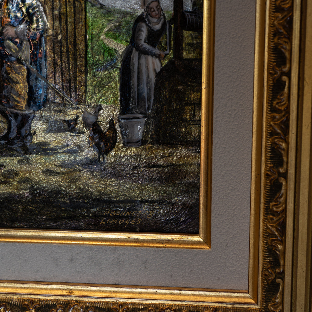 A close-up of a framed artwork showing a painted scene with figures and a rooster, bordered by a wide beige mat and an ornate gold frame.