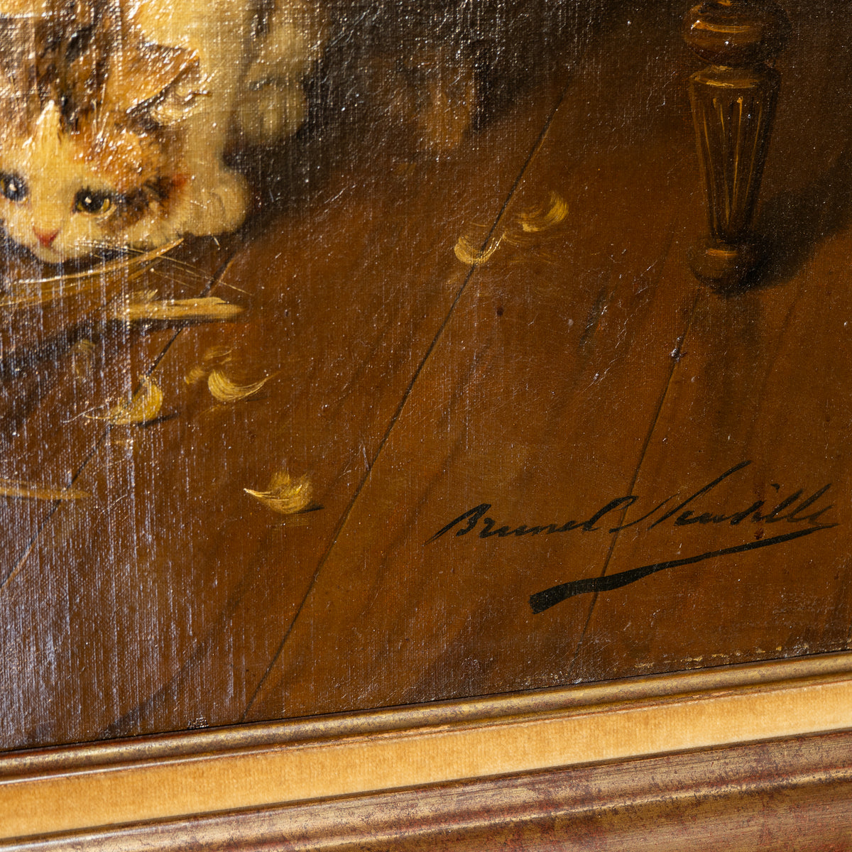Close-up detail of a framed painting showing part of a cat on a wooden floor with scattered feathers and an artist signature in the lower right.