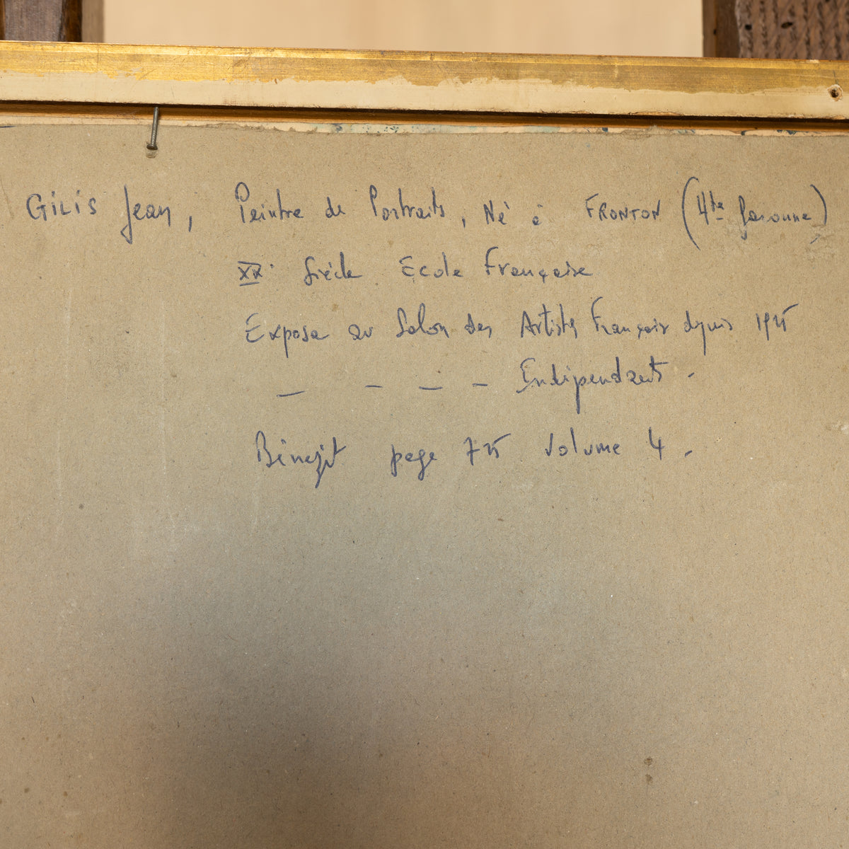 A beige handwritten notebook page with French text written in blue ink, photographed against a similar beige background with a wooden frame visible at the top.