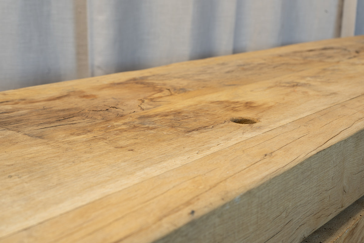 A close-up of a rustic reclaimed wood tabletop or shelf with natural grain, knots, and weathered texture.