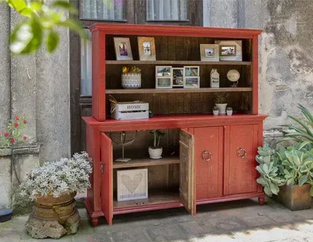 A red wooden buffet and hutch in a courtyard at Fiesta Furnishings in Scottsdale, Arizona. 