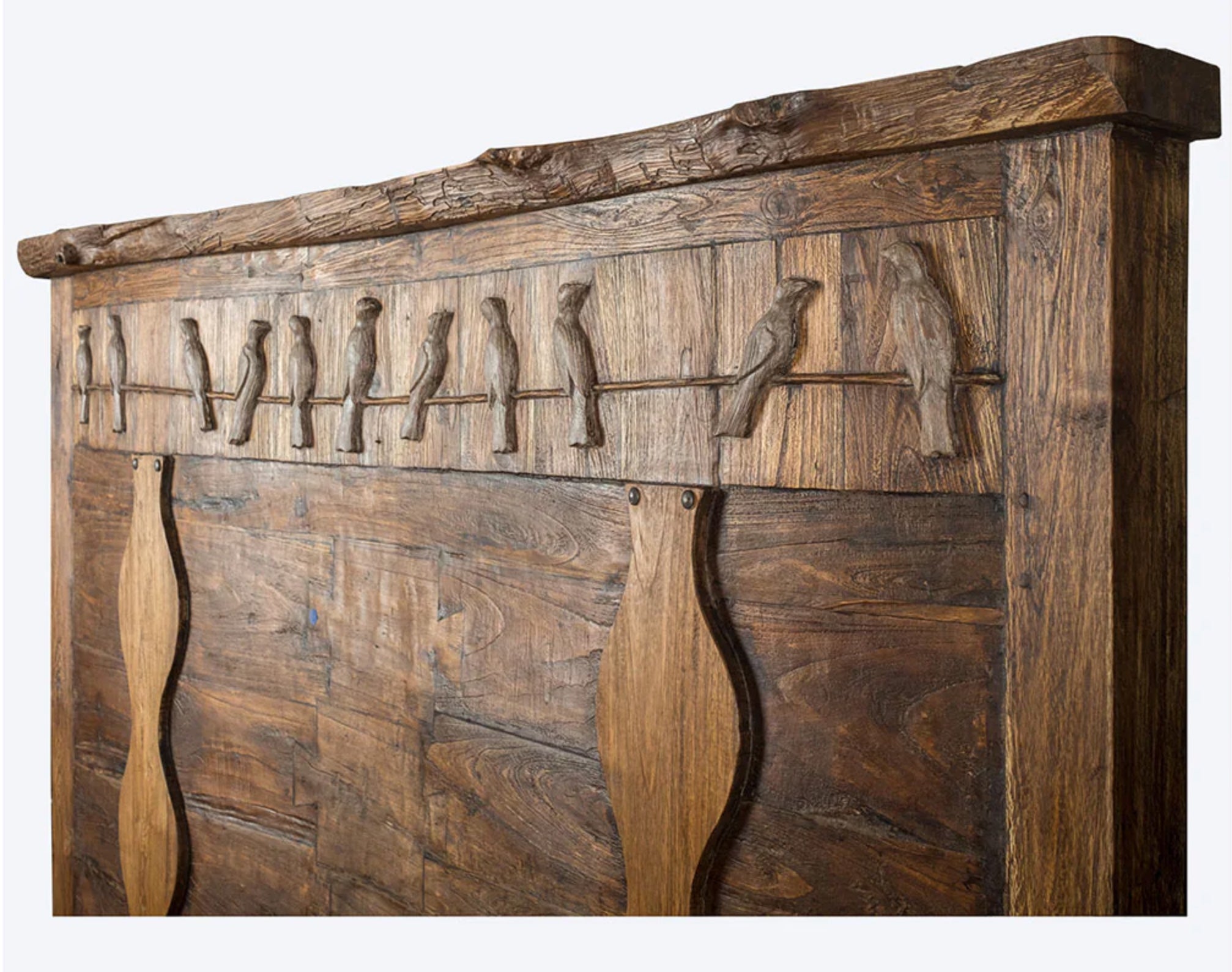 Wooden headboard with bird carvings on a white background