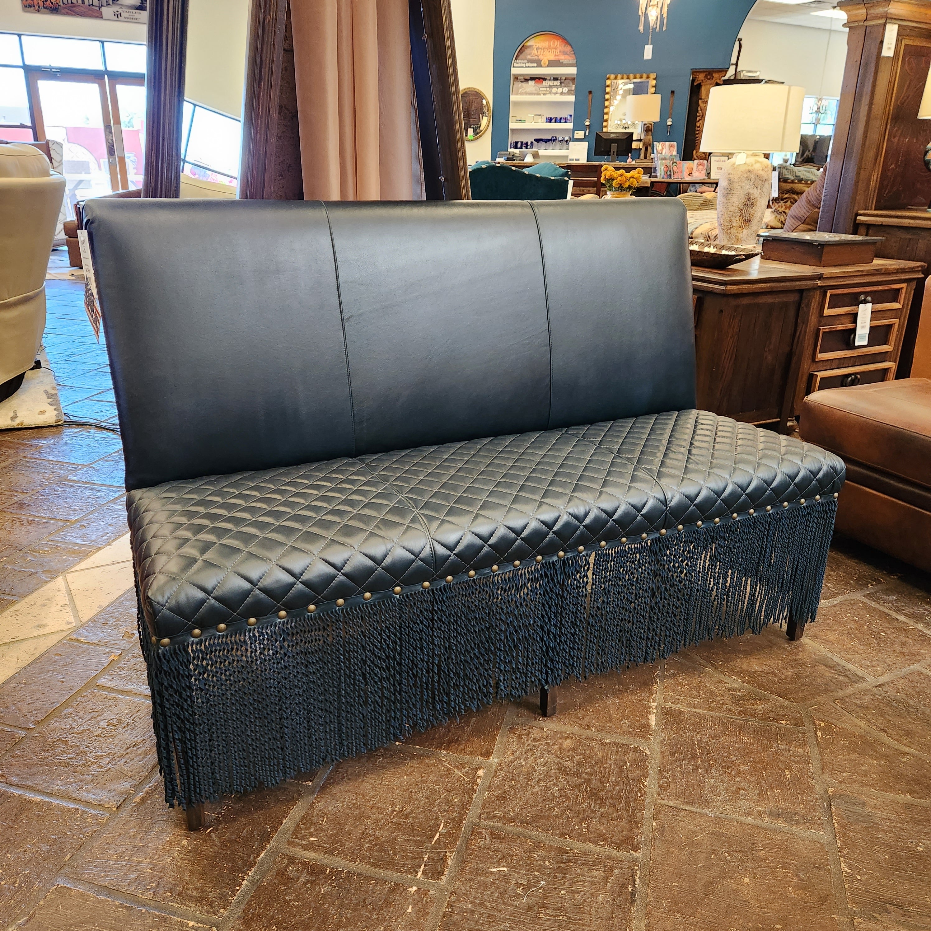 Navy leather bench with quilted design on a stone floor